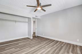 a bedroom with a ceiling fan and a closet with a sliding door