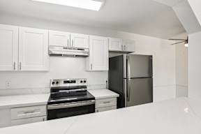 A kitchen with white cabinets and appliances.