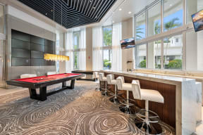 a game room with a pool table and bar