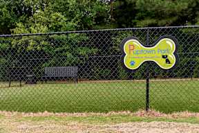 A sign for Puptown Park is displayed on a fence.