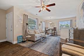 A living room with a couch, chairs, and a rug.