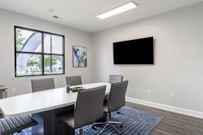 A conference room with a large table and chairs.