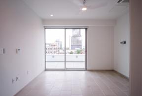 A large empty room with a view of the city through the window.