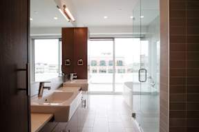 A bathroom with a row of sinks and a large window.