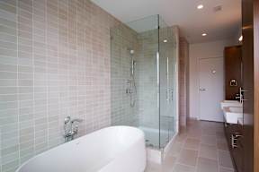 A white bathtub with a glass shower door in a bathroom.