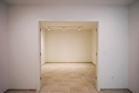 A white room with a doorway leading to another room.