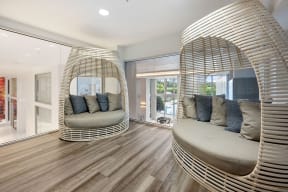 a living room with two chairs and a round mirror