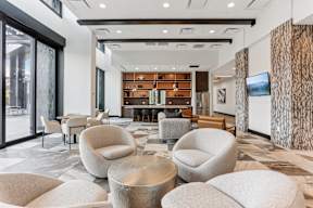 A modern living room with a large sofa and a TV on the wall.