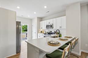 A kitchen with a white counter top and white cabinets.