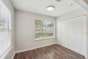 A room with a white door and a window with blinds.