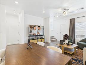 A modern dining room with a wooden table and chairs.