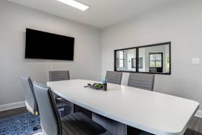 A conference room with a white table and chairs.