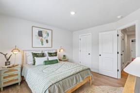 A bedroom with a bed, nightstand, and two lamps.
