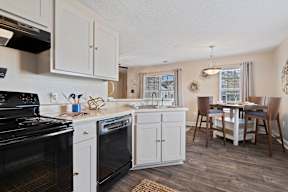 A kitchen with white cabinets and a black stove top oven.