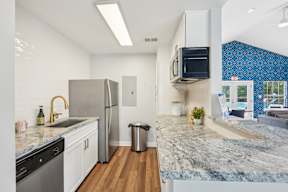 A kitchen with a granite countertop and stainless steel appliances.