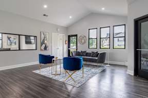 A living room with a blue chair and a grey couch.
