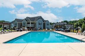A swimming pool in front of a row of houses.