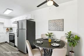 A modern kitchen with a dining table set for four.