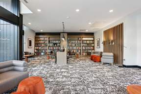 A library with a carpeted floor and bookshelves filled with books.