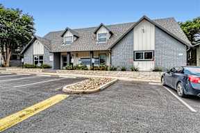 a house with a parking lot and a car in front of it