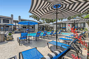 our patio is full of chairs and umbrellas and a pool