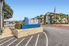 the sign for blu at the entrance of a parking lot