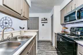 a kitchen with a sink and a stove and a microwave