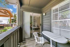 a balcony with a table and chairs and a door to a patio