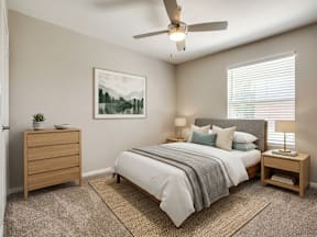 A bedroom with a bed, nightstand, and a painting on the wall.