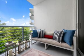 a balcony with a couch and pillows on it