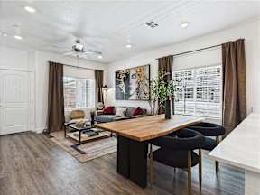 A modern living room with a wooden table and black chairs.