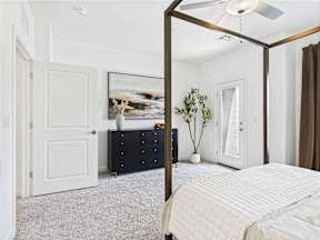 A bedroom with a four poster bed and a dresser.