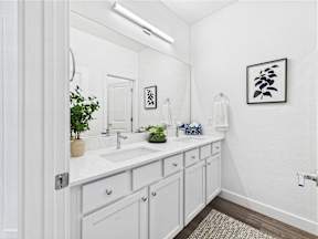 A bathroom with a white sink and a white cabinet.