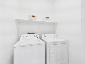 Two white front loading washing machines with blue and black buttons.