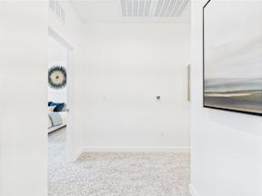 A room with a white wall and a large painting hanging on it.