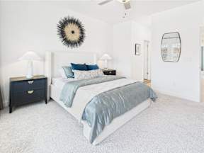 A bedroom with a bed, nightstand, and lamp.
