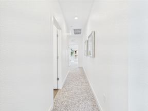 A long hallway with white walls and carpeting.