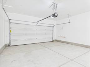 A garage with a white door and a white wall.