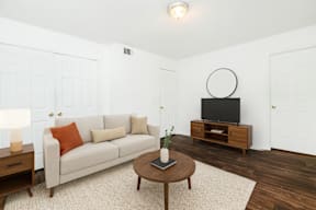 A living room with a couch, coffee table, and television.