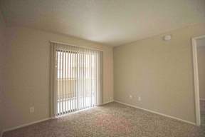 an empty living room with a sliding glass door