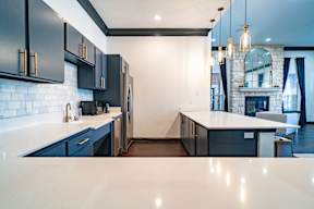 a kitchen with white countertops and blue cabinets and a fireplace