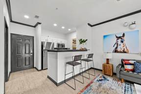 A modern kitchen with a bar area and a large painting of a horse on the wall.