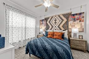 A bedroom with a large bed and a ceiling fan.