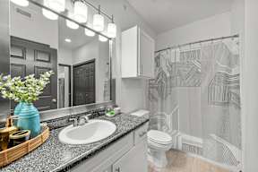 A bathroom with a white sink and a white toilet.