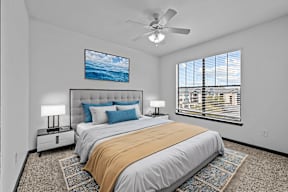 A bedroom with a large bed and a ceiling fan.