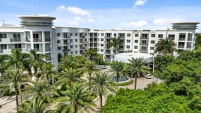 a large hotel building with palm trees in front of it