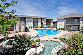 a swimming pool with a pool house and a resort style pool