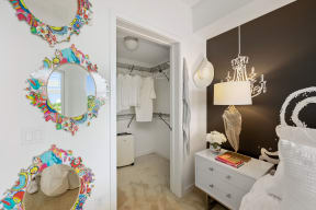 a bedroom with a closet and mirrors on the wall and a bed with a white