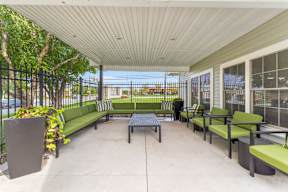 A patio with a green bench and a table.