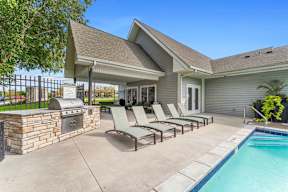 A house with a pool and lounge chairs.